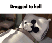 a mickey mouse pillow is on a bed with the words dragged to hell