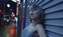 a woman is leaning against a building with her mouth open