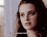 a close up of a woman 's face with the words that damned smile above her