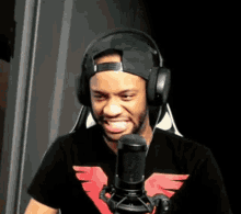 a man wearing headphones and a t-shirt with an eagle on it is talking into a microphone