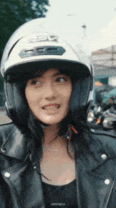 a woman wearing a helmet and a leather jacket has the letters sv on it