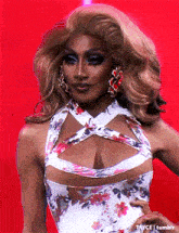 a woman in a floral dress with a plunging neckline is on a red background