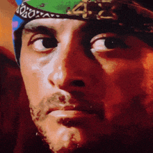 a close up of a man 's face with a bandana around his head