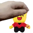 a hand is holding a stuffed toy that looks like a lego man .