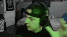 a man wearing headphones and a hat with the word legion on the back