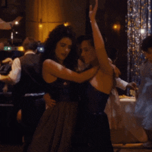 a woman in a black dress dancing with a man in a white shirt