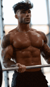 a shirtless man is holding a barbell in his hands