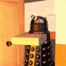 a dalek robot is holding a box of pizza on top of its head