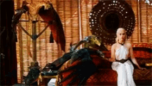a woman in a white dress is sitting on a couch next to a dragon statue .
