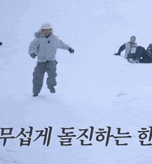 a man in a white jacket and hat is standing in the snow with korean writing on the bottom