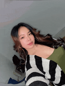 a woman in a green top and a black and white striped sweater