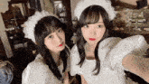 two women in white dresses are posing for a selfie