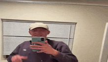 a man is taking a picture of himself in the mirror with his phone .