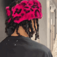 a person wearing a black shirt and a pink hat