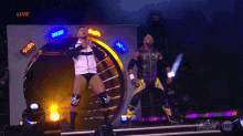 two wrestlers on a stage with the word live on the bottom left