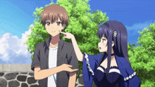 a boy and a girl are standing next to each other with the girl pointing at the boy 's face
