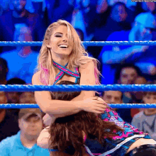 a woman is hugging another woman in a wrestling ring and the caption says the next thing