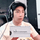 a man wearing headphones is sitting in front of a screen that says add a comment ..
