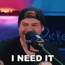 a man behind a microphone with the words " i need it " on the bottom