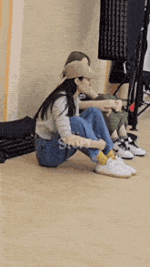 two women are sitting on the floor with the word story on the bottom