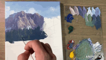 a painting of a mountain is being painted by a person