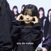 a girl in a black jacket with the words soy de mateo above her