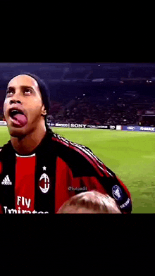 a soccer player is sticking his tongue out on a field