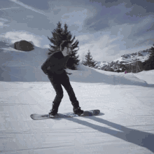 a man riding a snowboard on a snowy hill