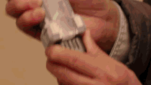 a close up of a person 's hands holding a white object .