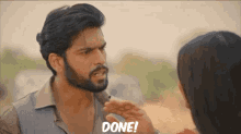 a man with a beard is talking to a woman who is saying done