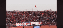 a shark family banner is displayed on a soccer field