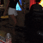 a woman in a black top and white shorts is sitting in front of a microphone