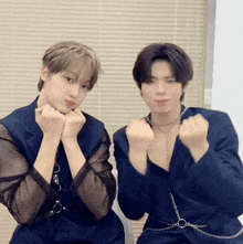 two young men are posing for a picture and one of them has a chain around his waist