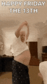 a man is dancing in a living room with his arms in the air .