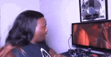 a woman is sitting at a desk in front of a computer screen .