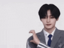 a young man is making a heart shape with his hands .