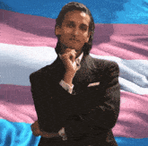 a man in a suit with his hand on his chin
