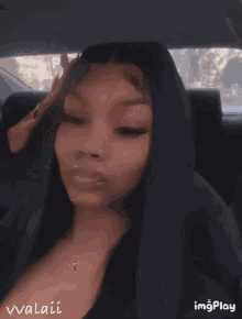 a woman sitting in the back seat of a car with her eyes closed and the name vvalai on the bottom