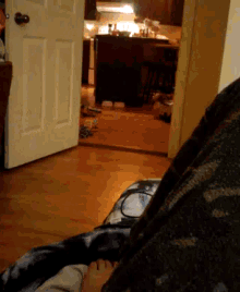 a person laying on a couch in a room with a kitchen in the background