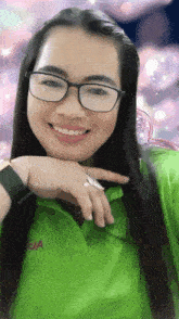 a woman wearing glasses and a green shirt that says da