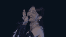 a woman is singing into a microphone and smiling .