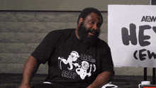 a man sitting in front of a sign that says aew crew