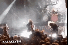 a crowd of people watching a concert with the word kataklysm on the bottom left