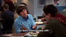 two men are sitting at a table and one of them is saying " you don 't wanna mess with me "