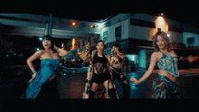 a group of women are dancing in front of a building that says ' o'leen ' on it