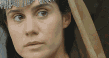 a close up of a woman 's face with a wooden stick in her hand