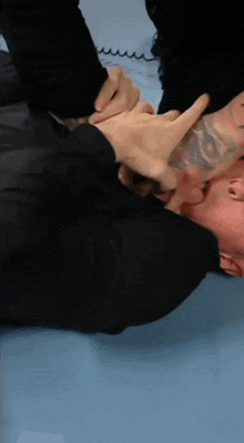 a person with a tattoo on their arm is laying on the ground
