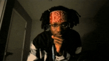 a man wearing a bandana and glasses eating something