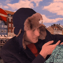 a man wearing a furry hat looks at something