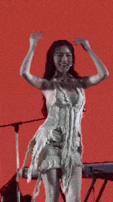 a woman in a white dress is dancing on stage